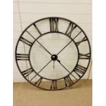 A metal large wall clock with roman numerals