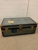 A vintage travel trunk with leather handles and brass corners