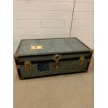 A vintage travel trunk with leather handles and brass corners