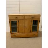 A antique pine kitchen unit with glazed doors to side, with drawers to top and bottom (H98cm