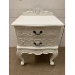 A white bedside with decorative scrolls to front (H66cm W50cm D40cm)