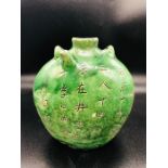 An Antique Chinese green bottle with writing to both sides.