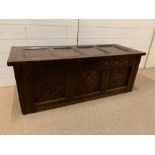 An oak four panel coffer with carving to front (H42cm W114cm D45cm)