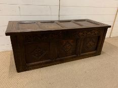 An oak four panel coffer with carving to front (H42cm W114cm D45cm)