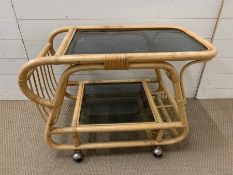 A bamboo drinks trolley on castors (H60cm W81cm D48cm)