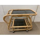 A bamboo drinks trolley on castors (H60cm W81cm D48cm)