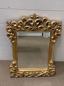 A small scrolled gilt mirror (60cm x 44cm)