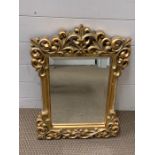 A small scrolled gilt mirror (60cm x 44cm)