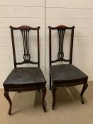 A Pair of Mahogany dining chairs with pierced splat backs.