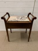 A piano stool with hand rails to sides and upholstered seat