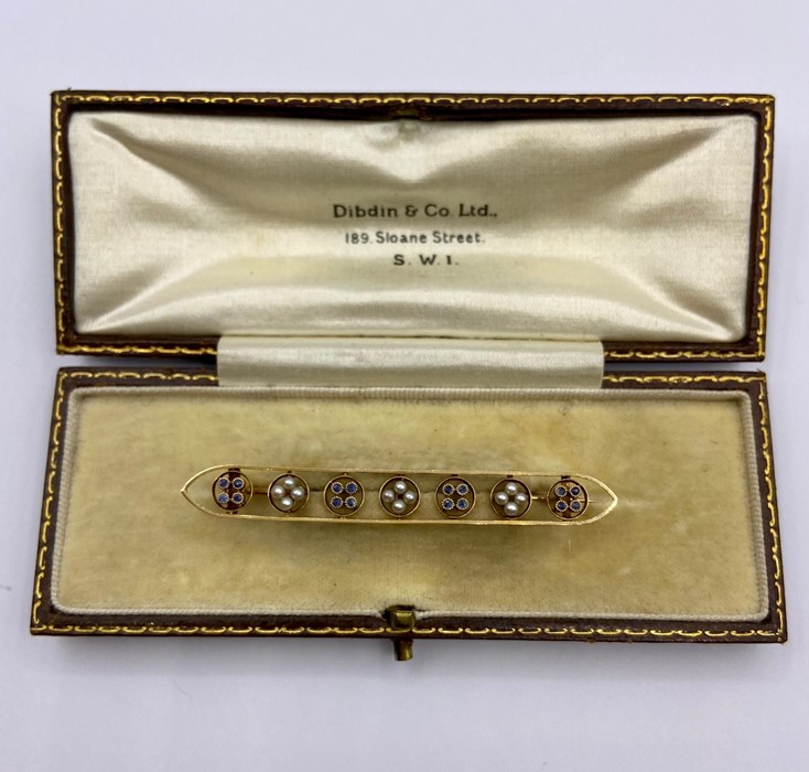 A Gold Bar brooch with seed pearls and sapphires. 6cm L