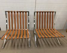 A pair of Barcelona chair frames with leather straps