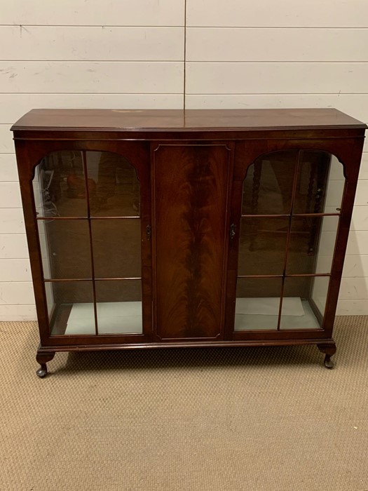 A glazed two door display cabinet with two glass shelves (H108cm W124cm D34cm)