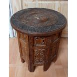An INDIAN wooden carved occasional table, (40 high; 38 diam).
