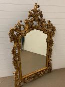 A wall hanging gilt mirror with scrolled details (H165cm W110cm)