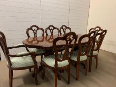 A burr elm style twin pedstal dining table with six chairs and two carvers with a fold out centre