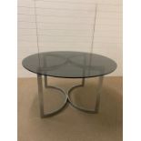 A 1960's smoked glass dining table on adjustable chrome legs (Diam 130 cm x High 72 cm)
