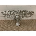An ornate metal wall sconce in the form of a shelf