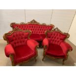 A three piece carved salon suite in red, button back