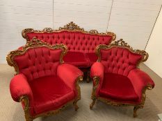 A three piece carved salon suite in red, button back