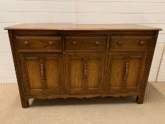 A Ercol Elm sideboard (H86cm W147cm D53cm)