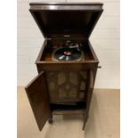 A wind up gramophone in a mahogany cabinet