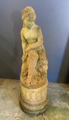 A garden statue of a lady sat down on a plith (H90cm)