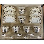 A cased set of six Aynsley porcelain teacups, saucers mounted in pierced silver stands. Presentation