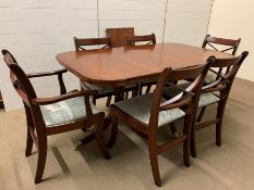 A mahogany dining table on turned legs ending on brass claw feet with four chairs and two carvers (