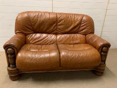 A leather two seater sofa (H95cm W140cm D80cm)