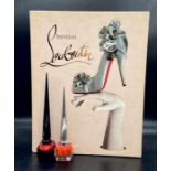 A large Christian Louboutin reference book by Rizzoli New York with two collectable Louboutin Beauty