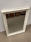 A white framed and carved mirror (H90cm W62cm)