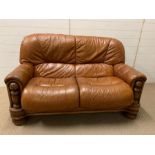 A leather two seater sofa (H95cm W140cm D80cm)