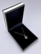 An 18ct white gold garnet and diamond pendant on gold chain.