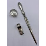 A silver pill box, whistle, and silver handled letter opener.