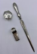 A silver pill box, whistle, and silver handled letter opener.