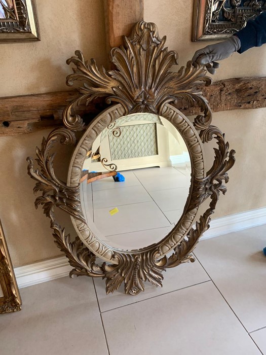 A 20th century giltwood oval mirror with floral carving