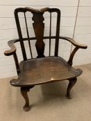 An oak open armchair on cabriole legs and spindled back