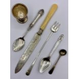 A selection of silver items to include an egg cup and spoons, etc.