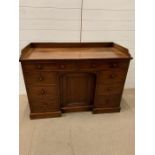 A mahogany desk with drawers to sides and cupboard to knee hole (H78cm W120cm D54cm)