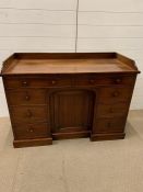 A mahogany desk with drawers to sides and cupboard to knee hole (H78cm W120cm D54cm)