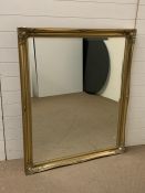 A large gilt frame mirror with scrolled detail to corners (H130cm W107cm)