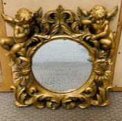 A small cherub themed wall mirror.