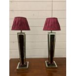 A pair of contemporary table lamps with mirrored sides and base