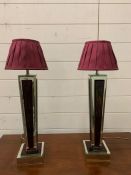 A pair of contemporary table lamps with mirrored sides and base