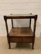 A mahogany two tier side table, terminating in brass castors