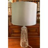 A cut glass table lamp with grey shade