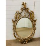 A gilt frame circular mirror with carved details