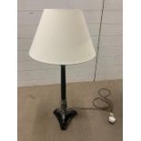 A black column table lamp with leaf moulded and tri-form base