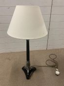 A black column table lamp with leaf moulded and tri-form base